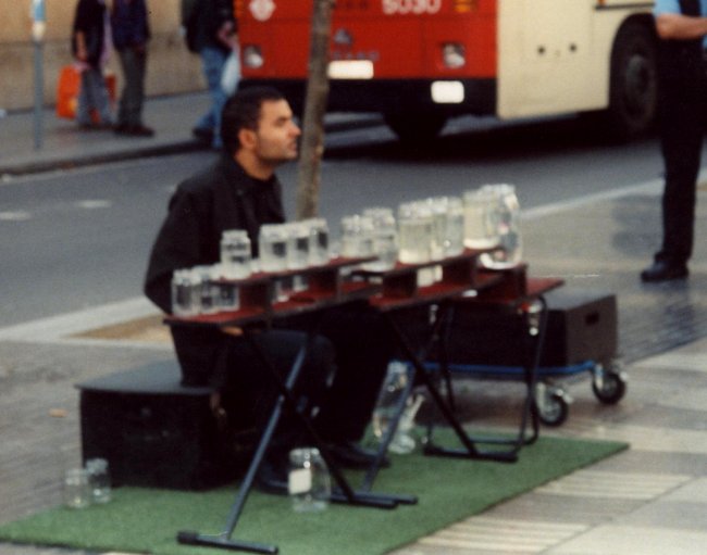 Busker playing a water-jar xylophone
